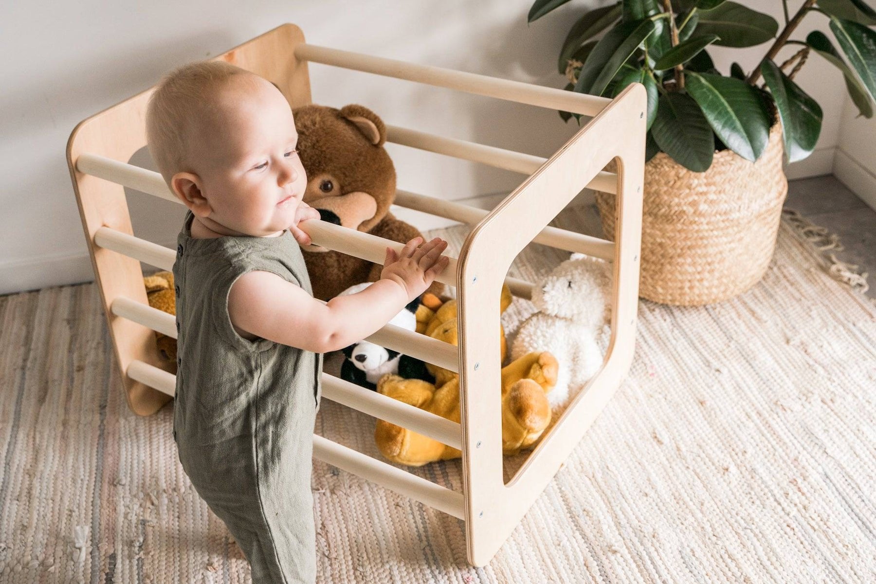 1. Toddler interacting with Ewart Woods square gym filled with toys on a woven rug