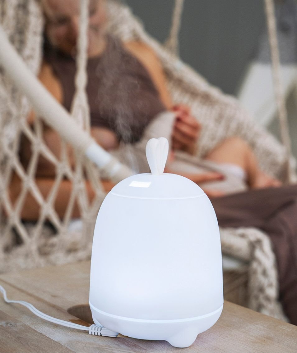 3. White Rabbit & Friends diffuser lamp with bunny ears emitting mist in a cozy setting