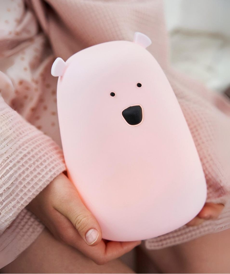 1. Child holding pink bear lamp, wearing pink robe, providing soft light