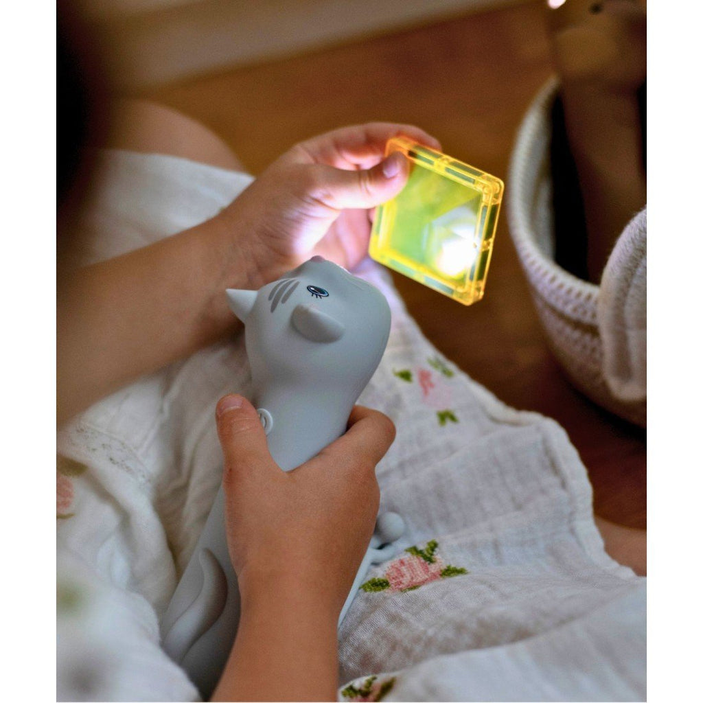 1. Child holding cat-shaped flashlight and yellow block, both illuminated