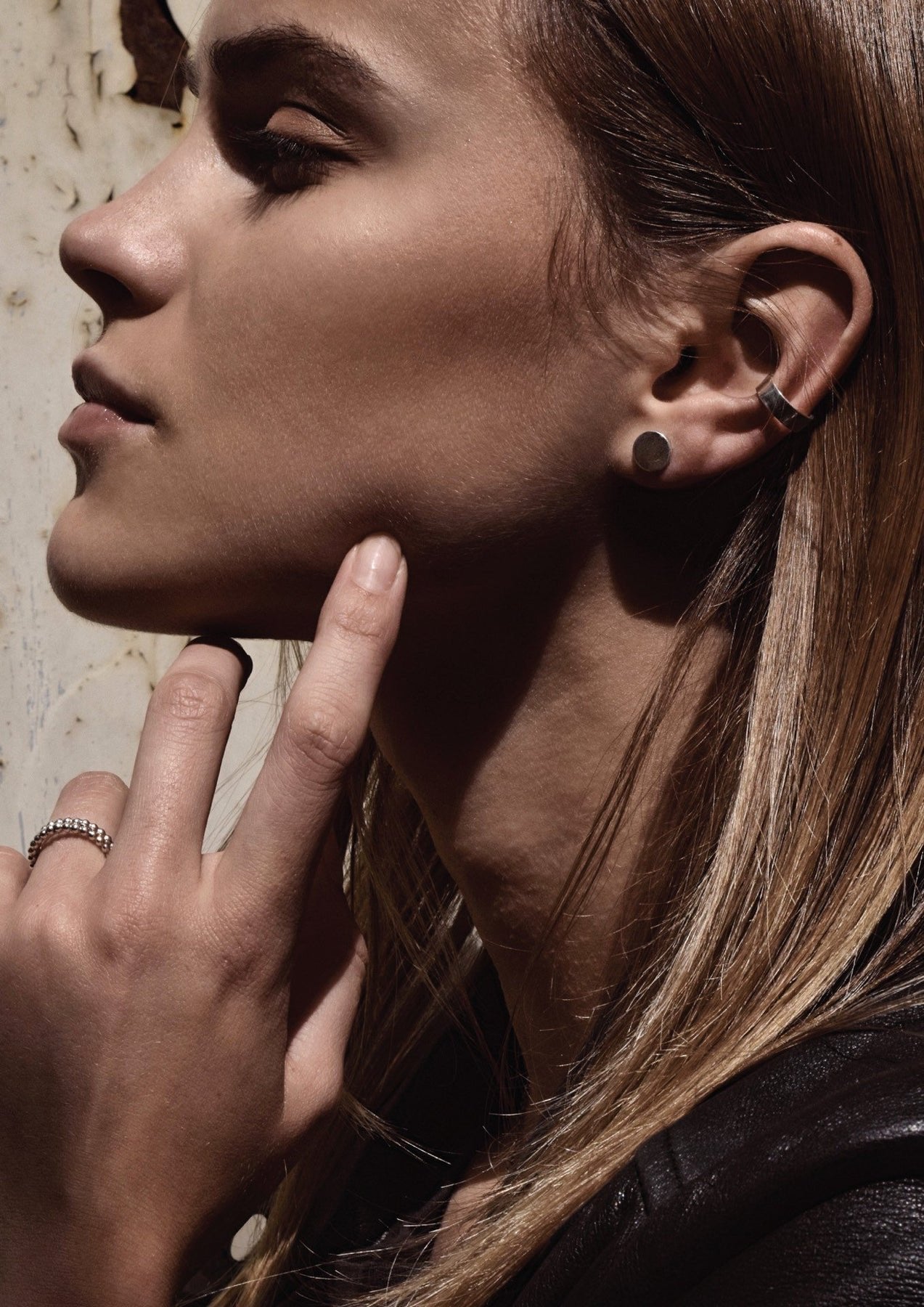 3. Side profile of woman wearing NO MORE flat ear cuff in silver, paired with a stud earring, emphasizing modern style