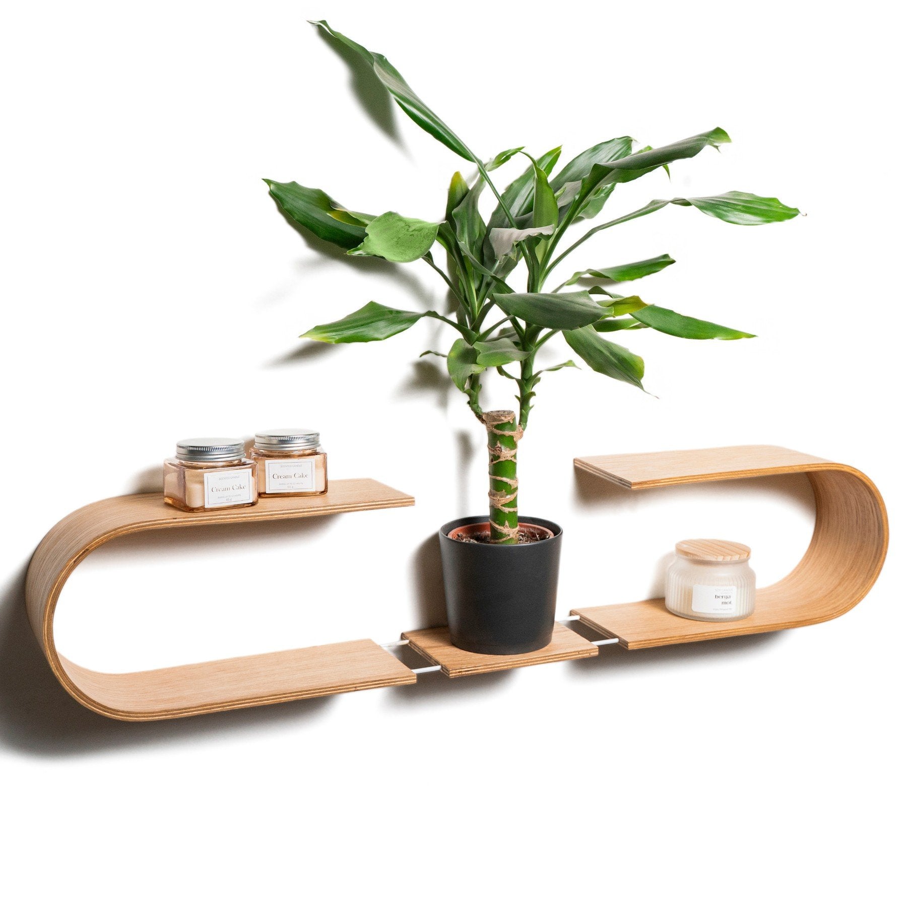 1. Oval wooden wall shelf with plant and candles, showcasing modern design in a home setting