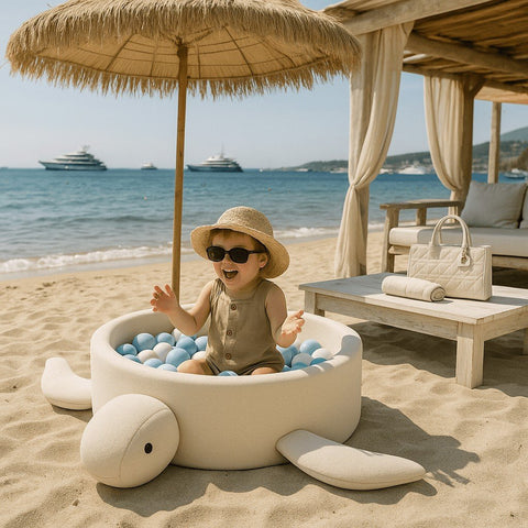 1. Child playing in turtle-shaped ball pit on a beach under a straw umbrella