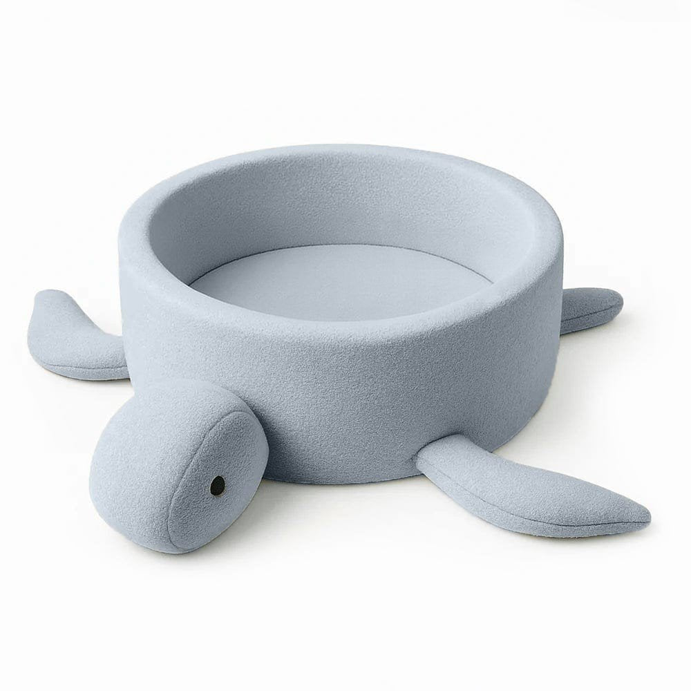 1. Turtle-shaped baby ball pit in dusty ice blue boucle fabric with soft fins, shown empty on a white background