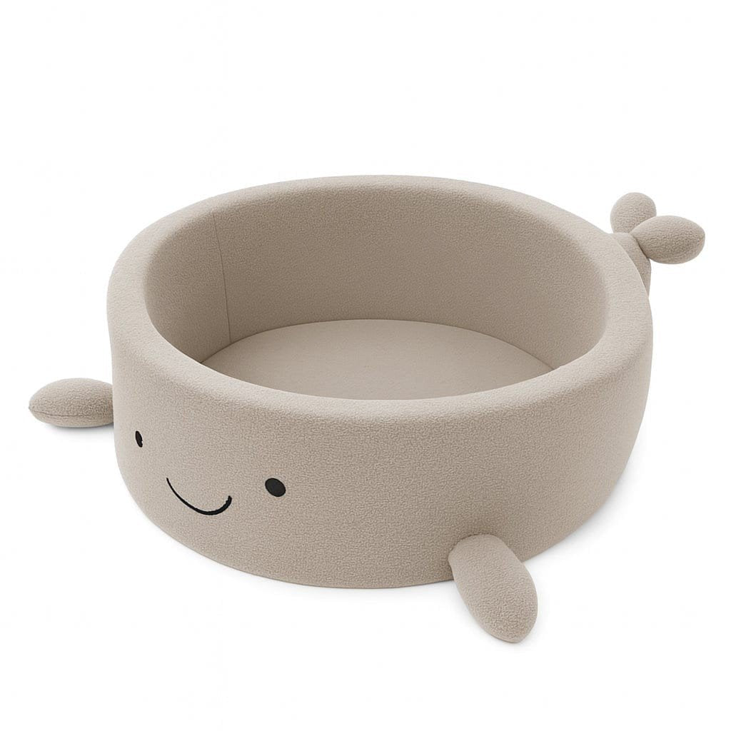 1. Beige whale-shaped foam baby ball pit with soft boucle finish and smiling face, shown empty on white background