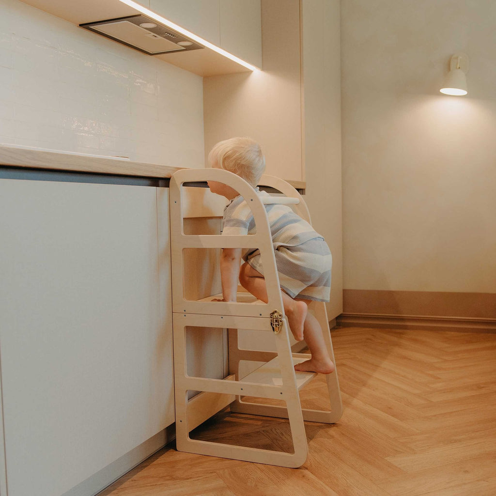 17. Child climbing natural birch kitchen tower at kitchen counter