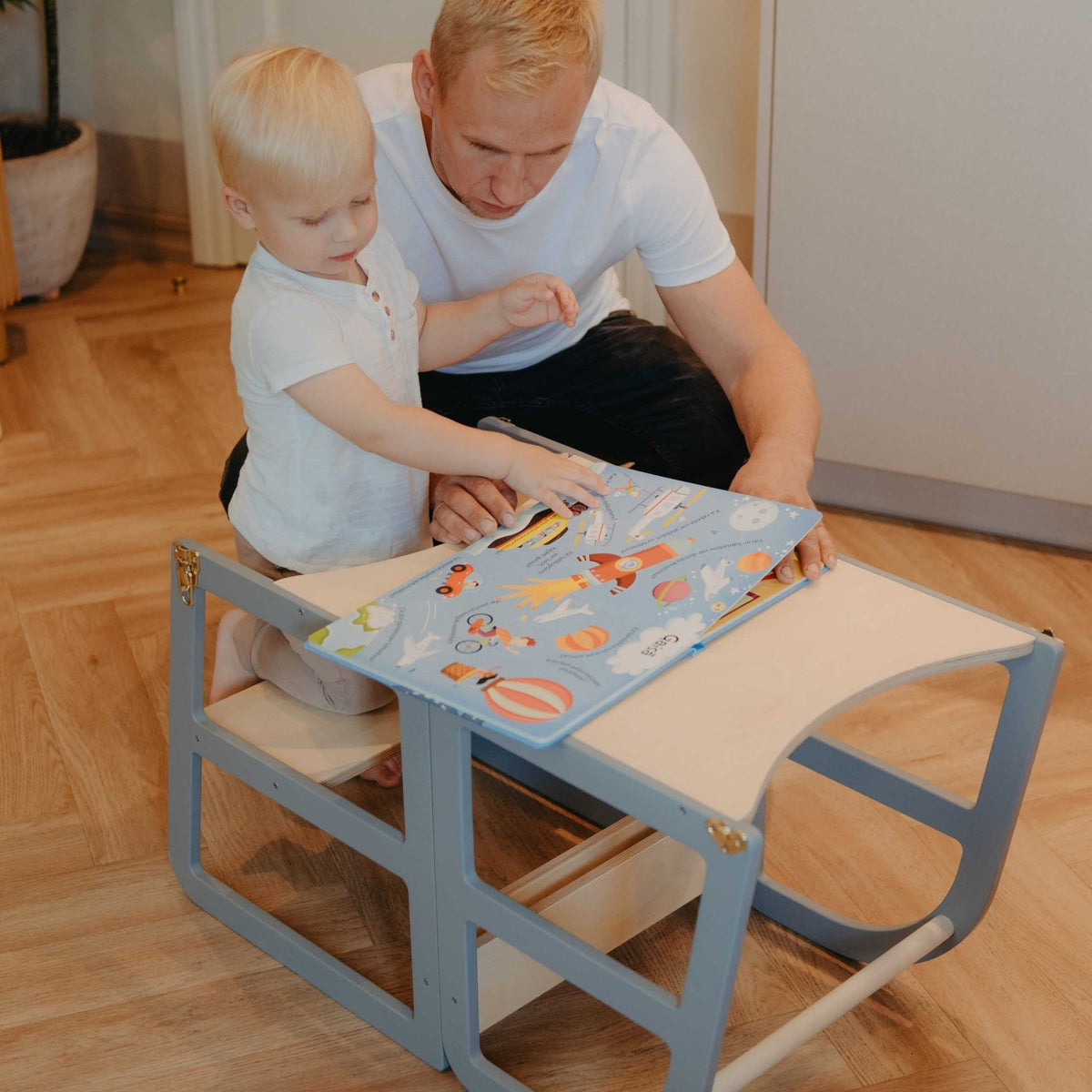 6. Child and adult reading book on grey kitchen tower in table mode