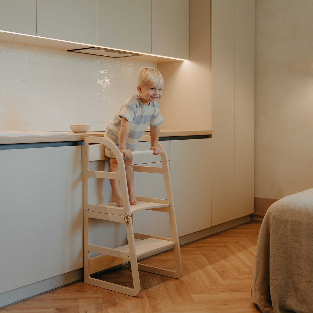 1. Child using natural birch kitchen tower at counter in modern kitchen
