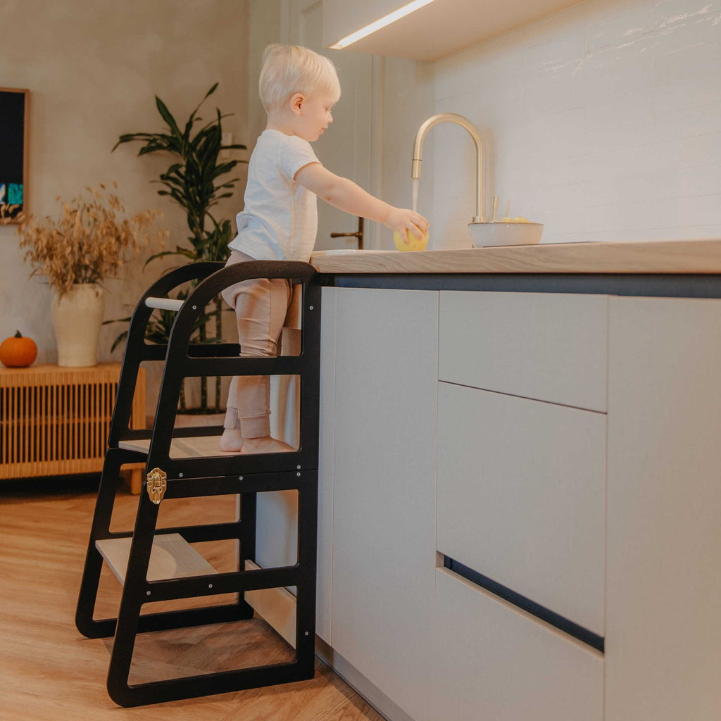 3. Child using black kitchen tower at sink in contemporary kitchen