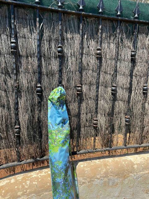 4. HAPPYSWEEDS parasol in carrying case with forest print leaning against rustic fence