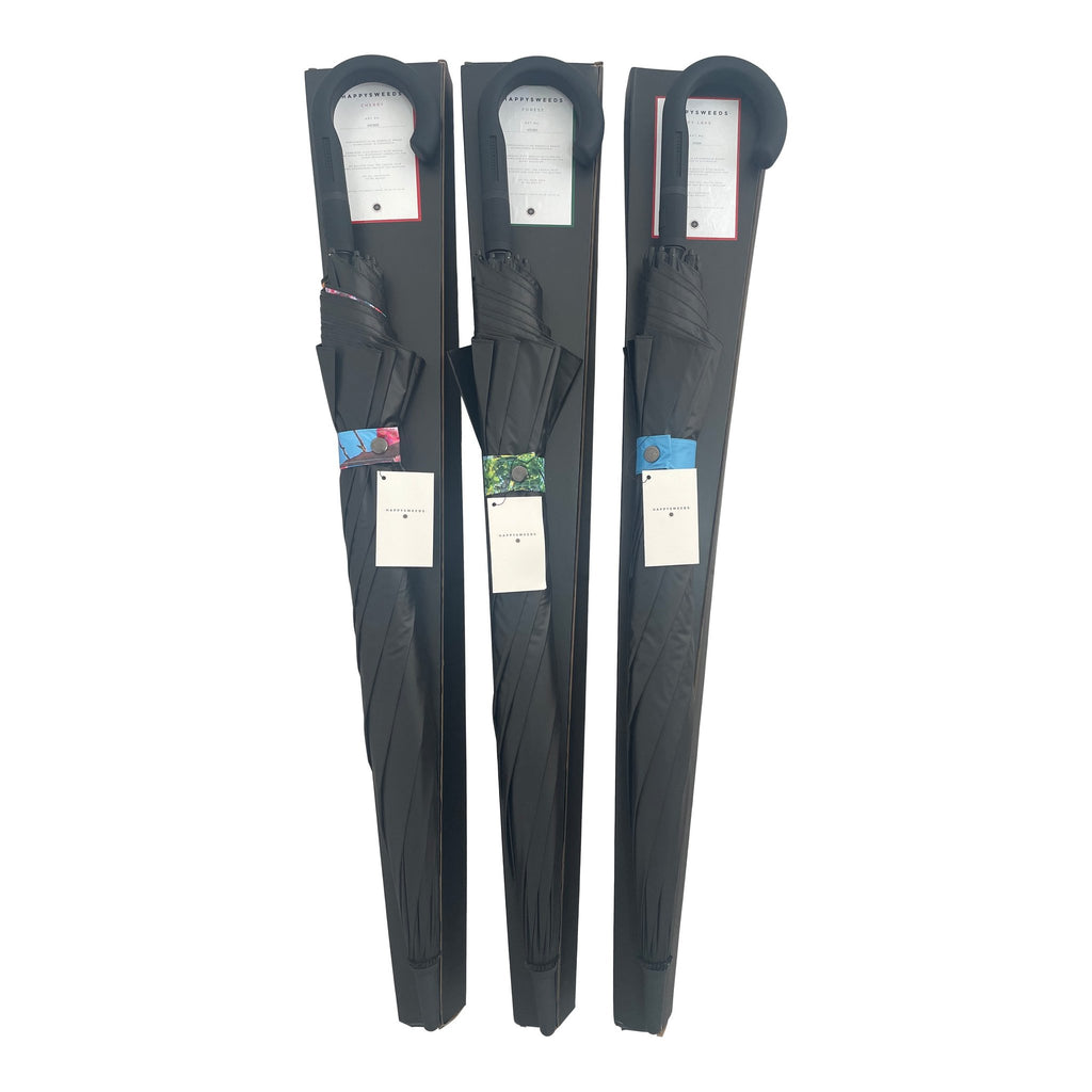 2. Three packaged large umbrellas with black covers and visible forest design tags, highlighting brand HAPPYSWEEDS
