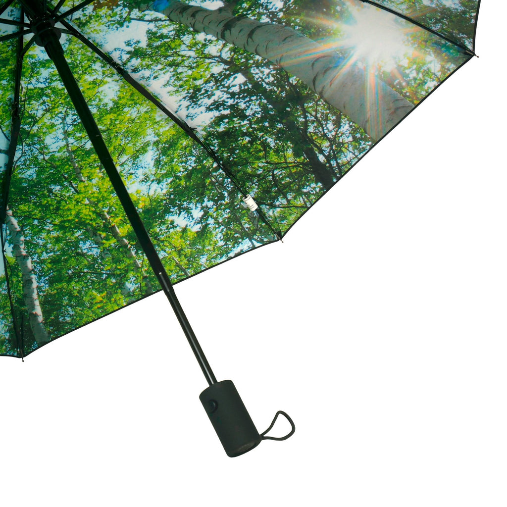 3. Close-up of forest print umbrella with sunlight filtering through leaves