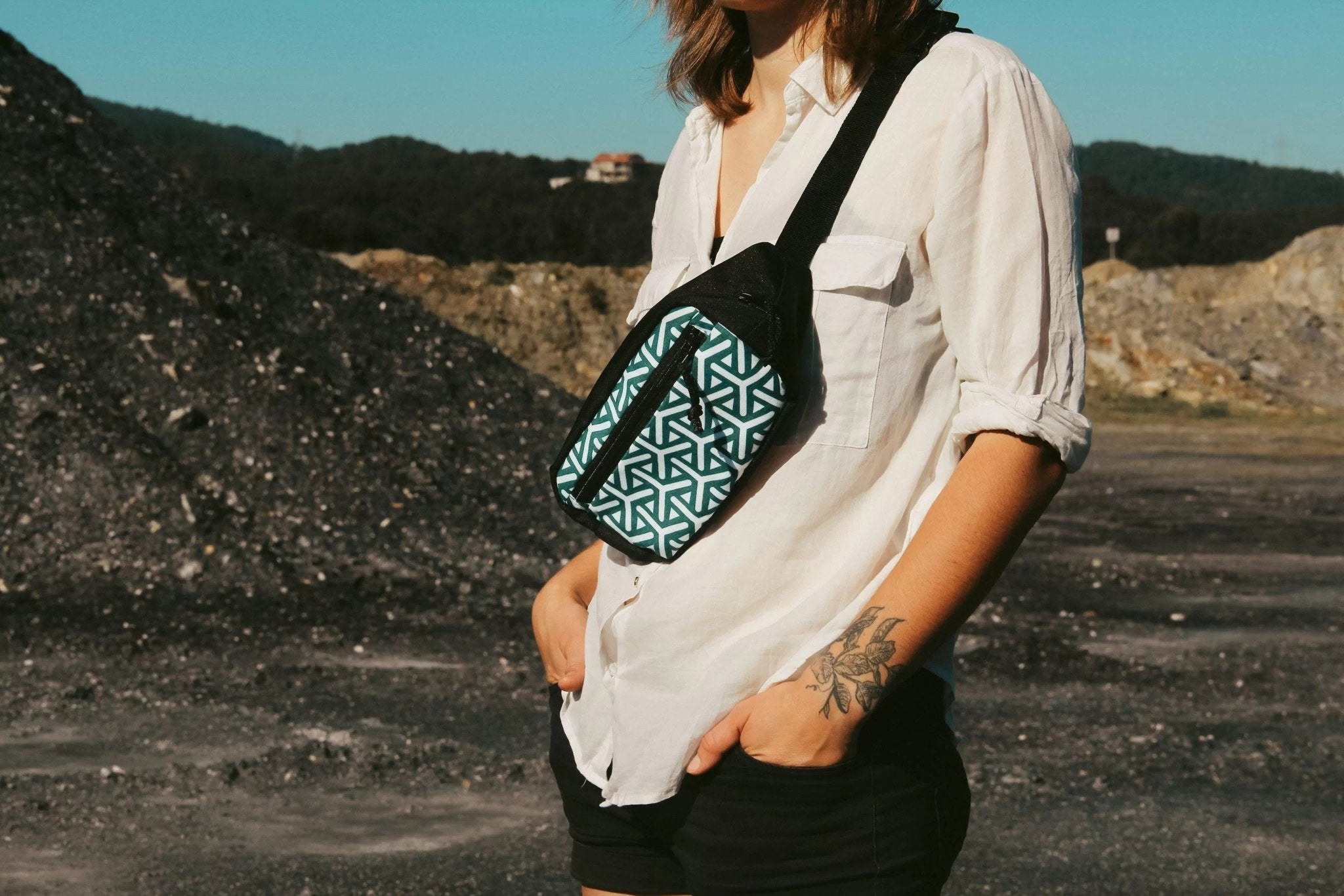 1. Woman wearing Drinbags HEART BEAT waist bag with geometric pattern, styled crossbody in outdoor setting