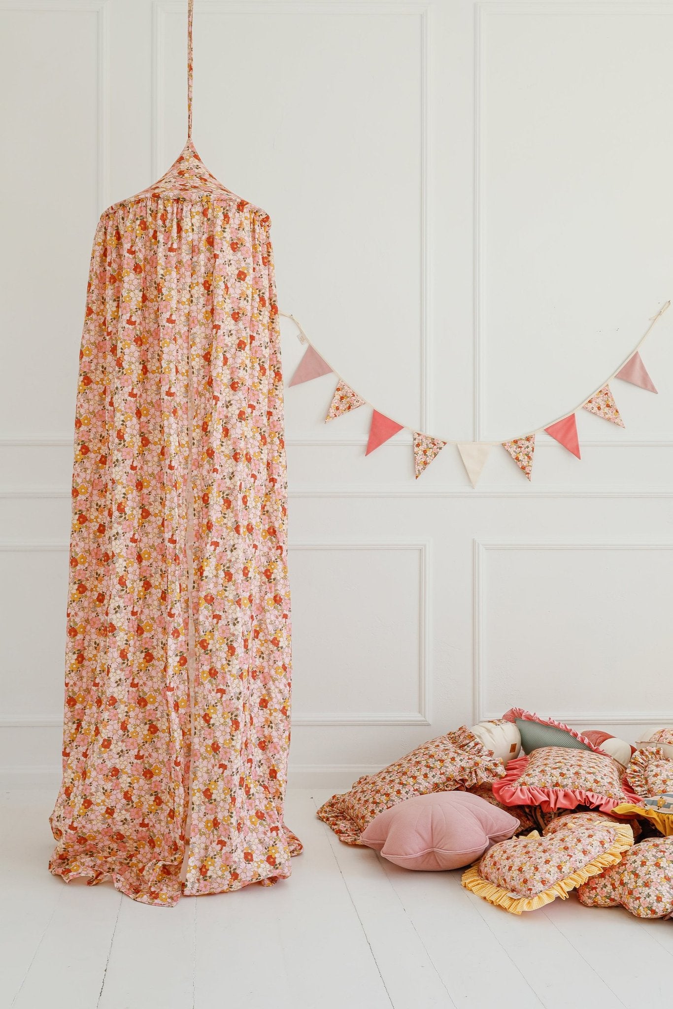 3. Floral canopy and garland in a child's room with assorted pillows on the floor