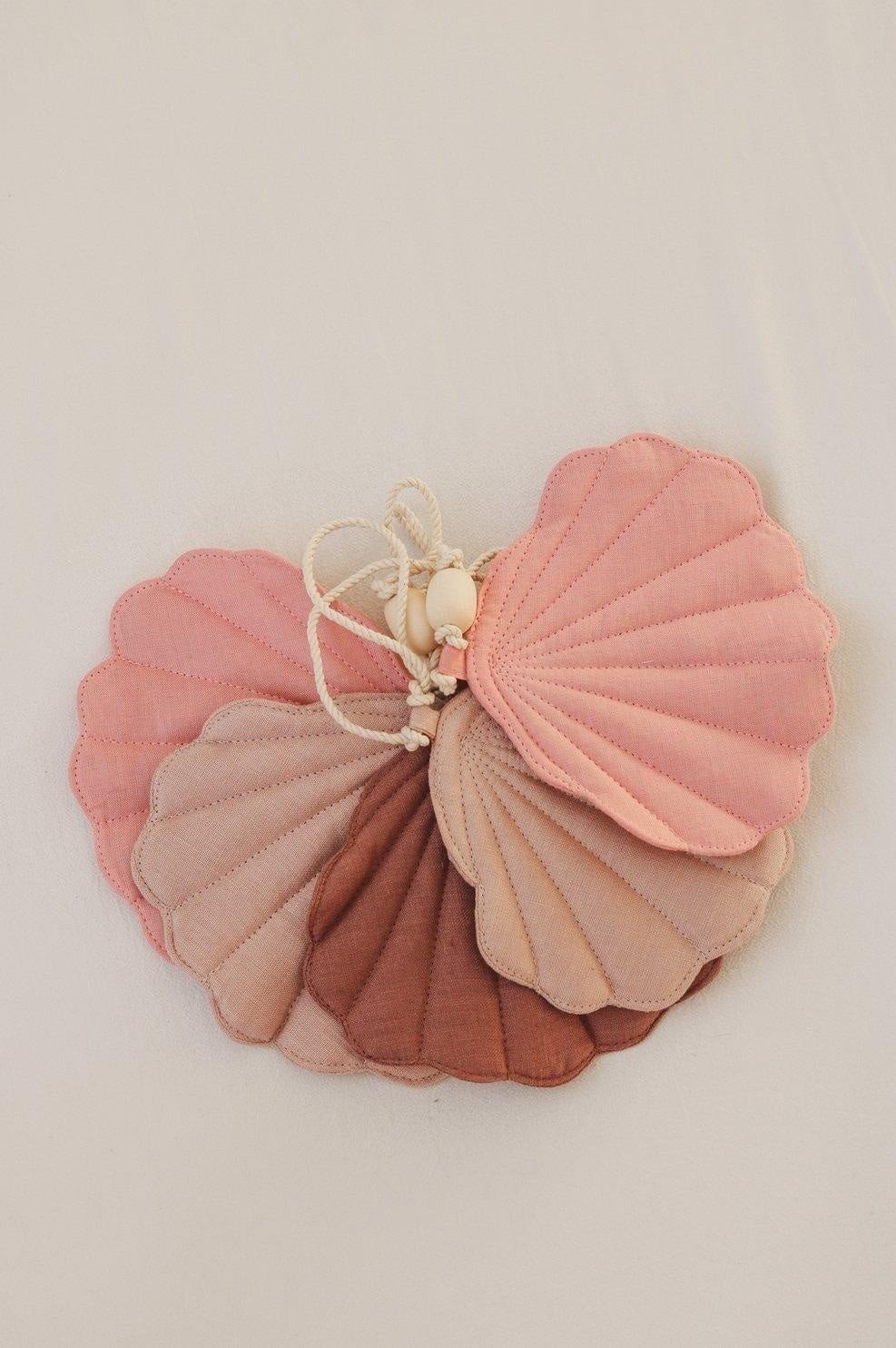 4. Flat lay of powder pink shell garland with five linen pendants in pink shades and wooden beads on a cotton string