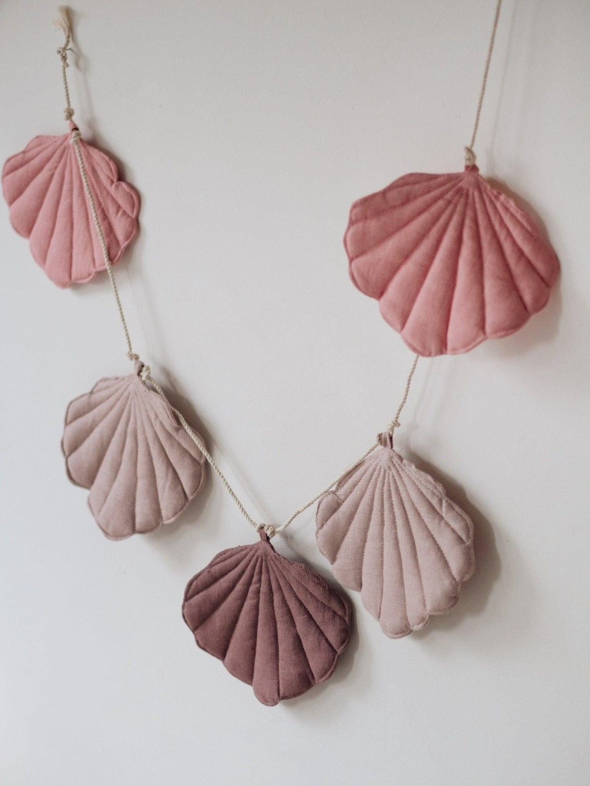 2. Close-up of powder pink shell garland with five linen pendants in dark pink, powder pink, and marsala on a cotton string