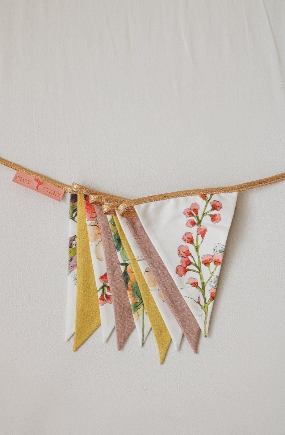 3. Close-up of floral and solid color garland with triangular pendants in yellow, pink, and floral patterns