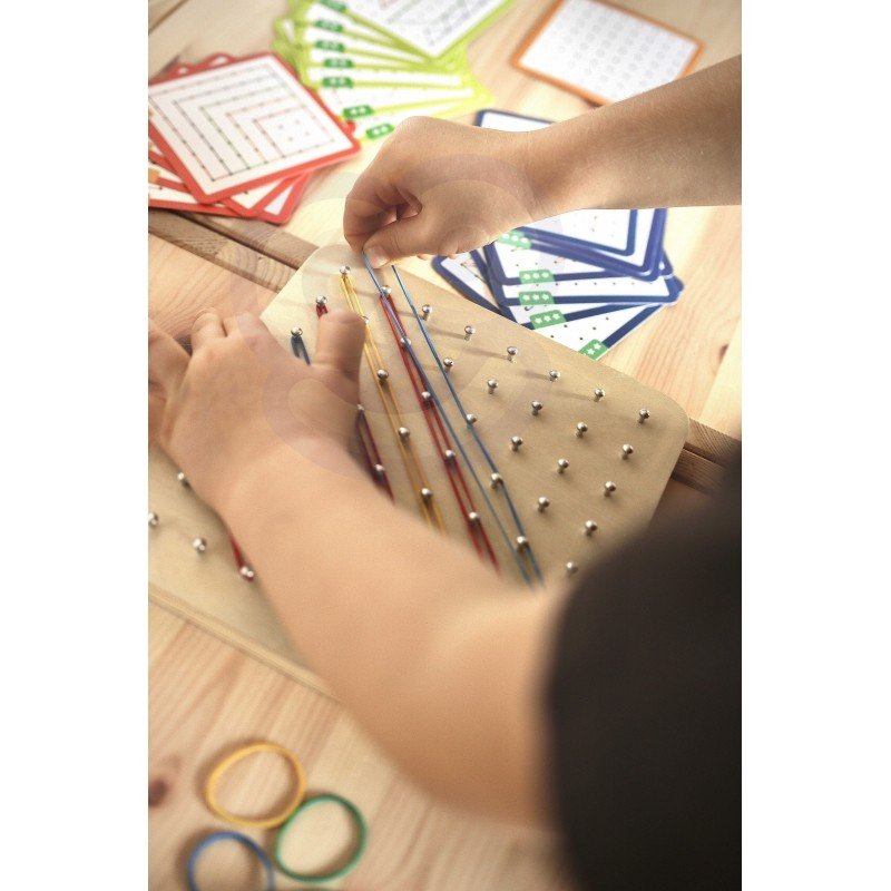 5. Child's hands arranging rubber bands on Woopie Green Geoplan board with pattern cards in background