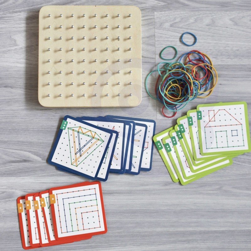 2. Woopie Green Geoplan set with wooden board, rubber bands, and pattern cards on grey wooden floor