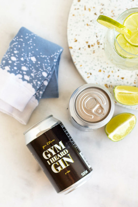 2. Overhead view of SEIK 'Gym I Heard Gin' socks and can, styled with lime and drink