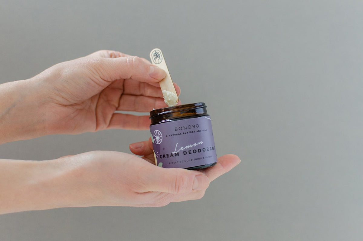 3. Hands holding BONOBO Lavendel Deodorant-Cream jar with wooden spatula in studio