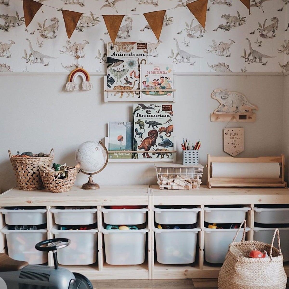 6. Children's playroom with dinosaur wallpaper, storage bins, and decorative bunting