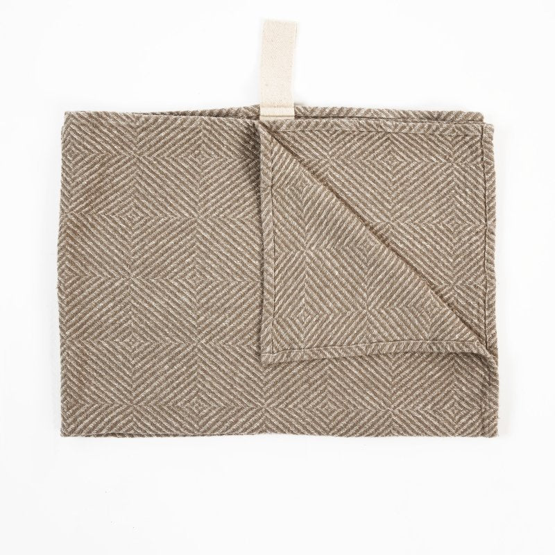 2. Beige linen towel with checkered fishbone pattern, partially folded, with white cotton hanger on white background