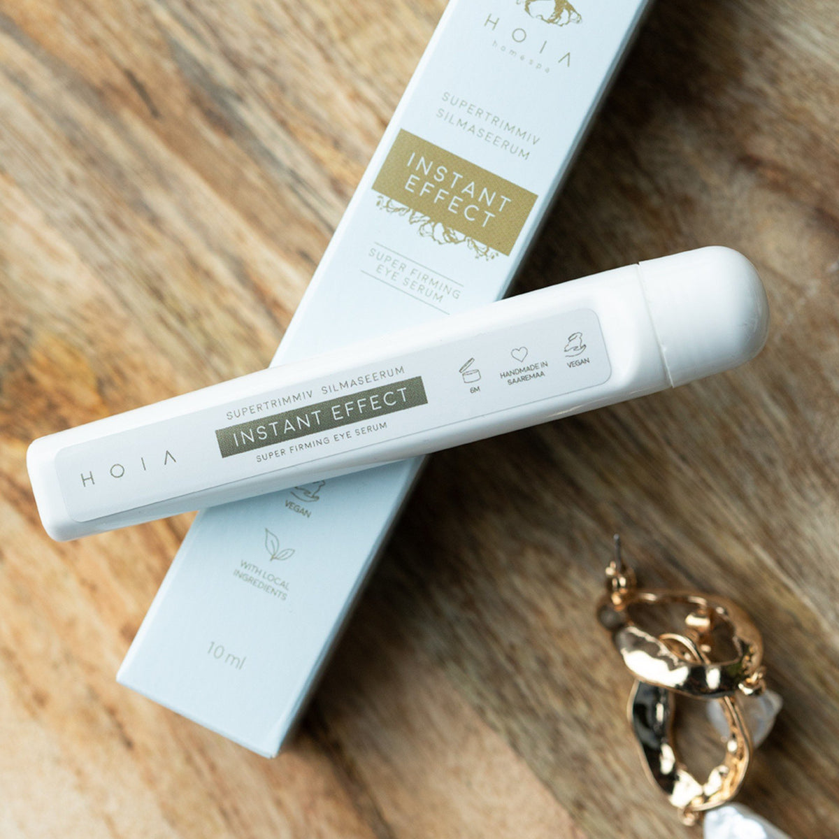 5. HOIA Instant Effect Super-Firming Eye Serum with packaging on wooden surface