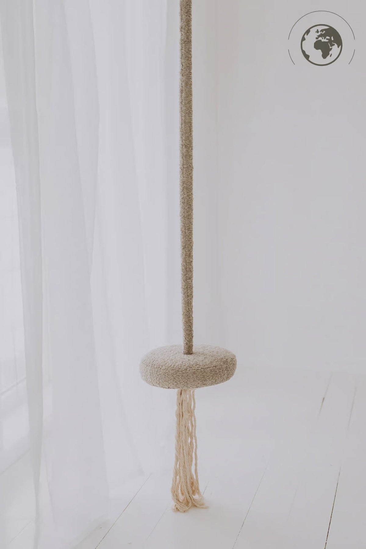 1. Children's bouclé pearl white swing with cotton rope hanging in a minimalistic white room