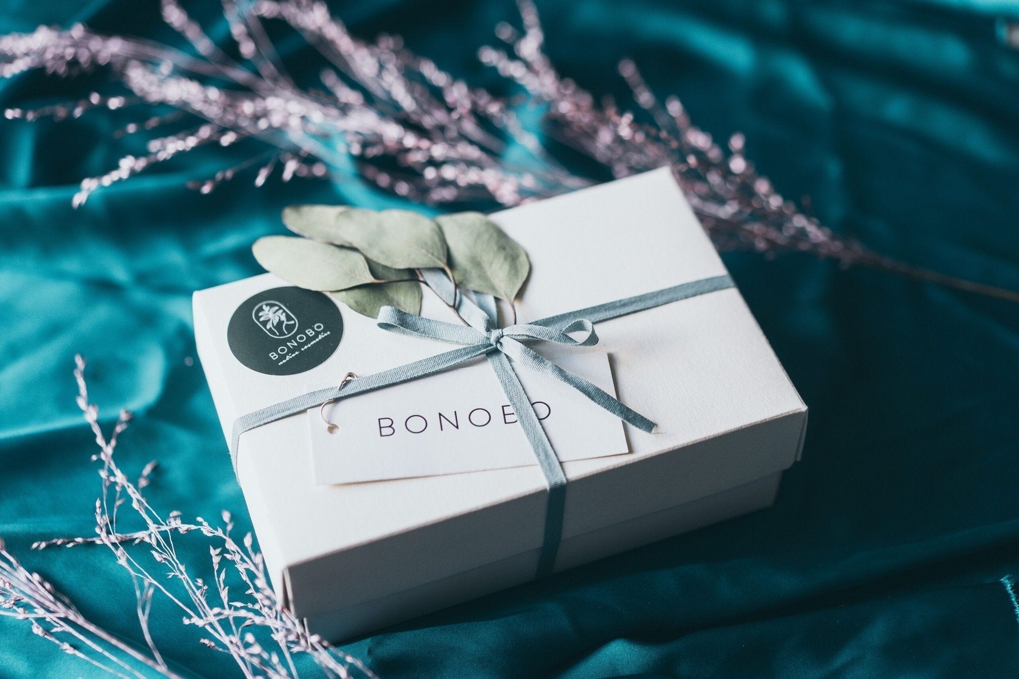 4. BONOBO gift box with ribbon and eucalyptus on teal fabric