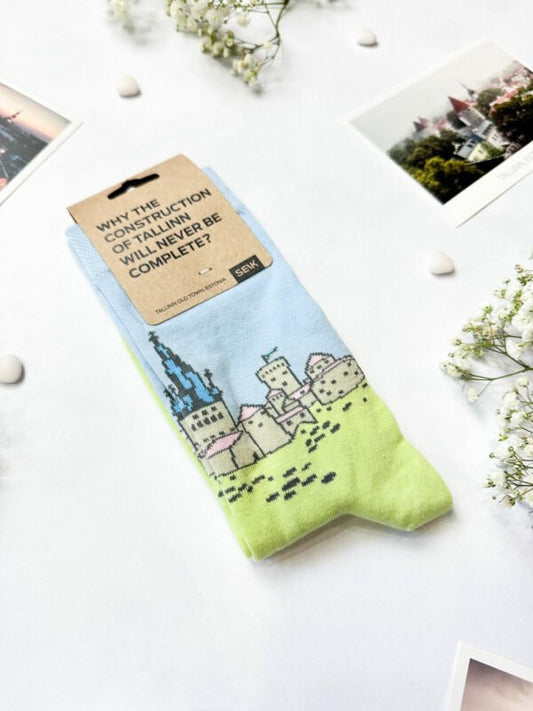 1. SEIK Old Town Tallinn Estonian socks with vibrant cityscape design, shown in packaging with text 'Why the construction of Tallinn will never be complete?'
