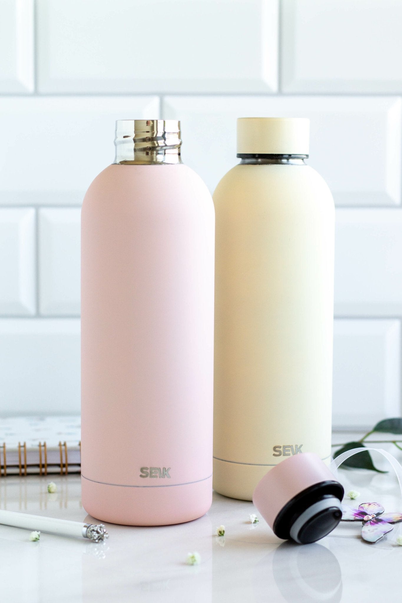 1. SEIK pink and cream water bottles with vacuum-insulated caps on marble surface