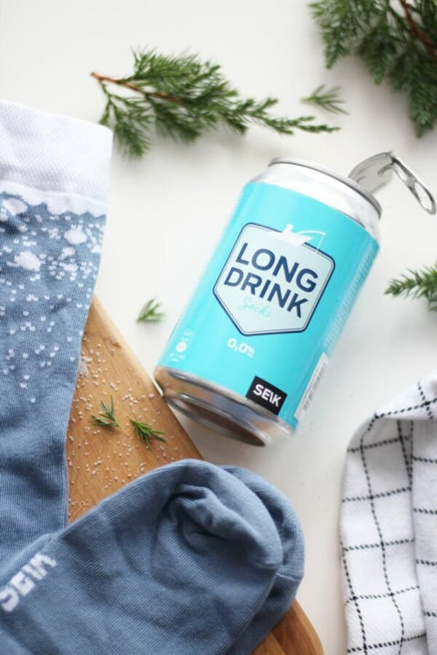 1. SEIK Long Drink Socks for men in blue with white speckled pattern, shown with Long Drink can and greenery