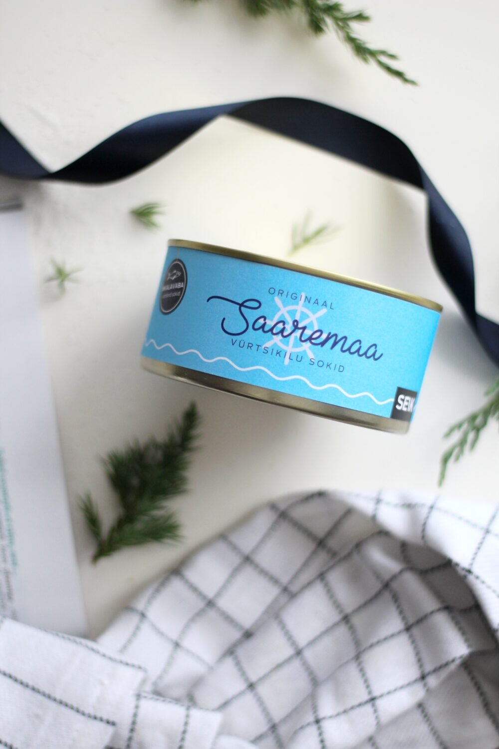 13. Saaremaa Vürtsikilu Socks packaging in blue tin with SEIK branding, styled with greenery and ribbon