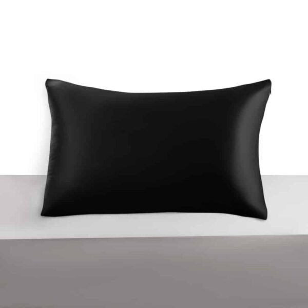 26. Single black silk pillowcase on grey surface, highlighting luxurious finish