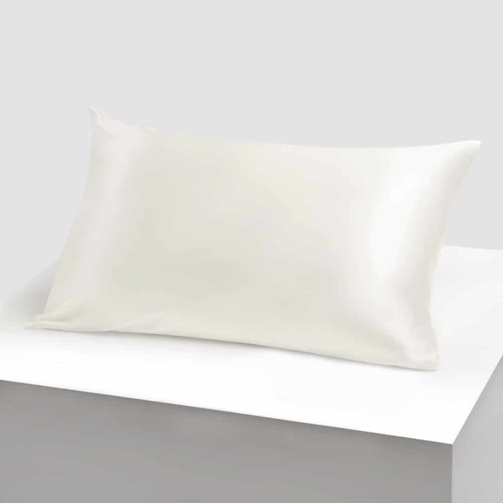 3. Ecru Mulberry silk pillowcase on a white platform, emphasizing sleek texture