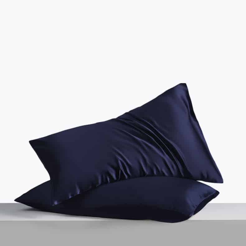 24. Pair of navy Mulberry silk pillowcases on a grey surface, emphasizing elegance