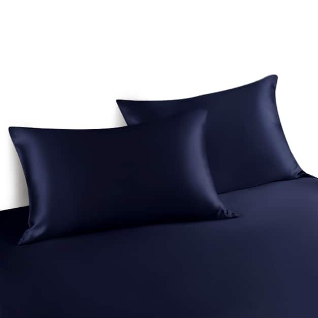22. Pair of navy Mulberry silk pillowcases on a matching bedspread, showcasing luxury