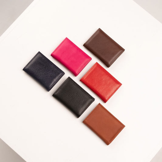 1. Flat lay of Papillon Leather Card Holder 21-46 in Cognac, Dark Brown, Red, and Black, showcasing compact design and color variety