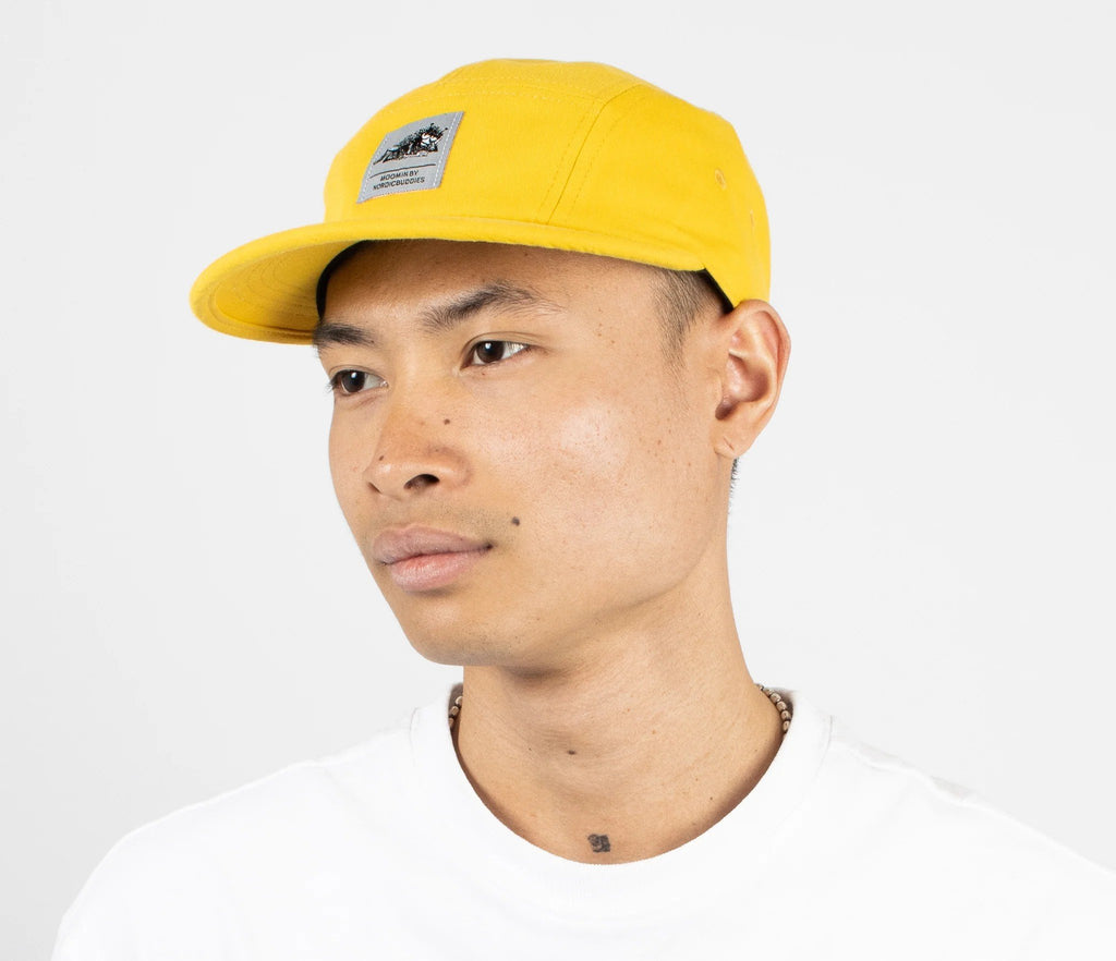 1. Man wearing yellow Moomin by NordicBuddies five panel cap with visible logo, white background