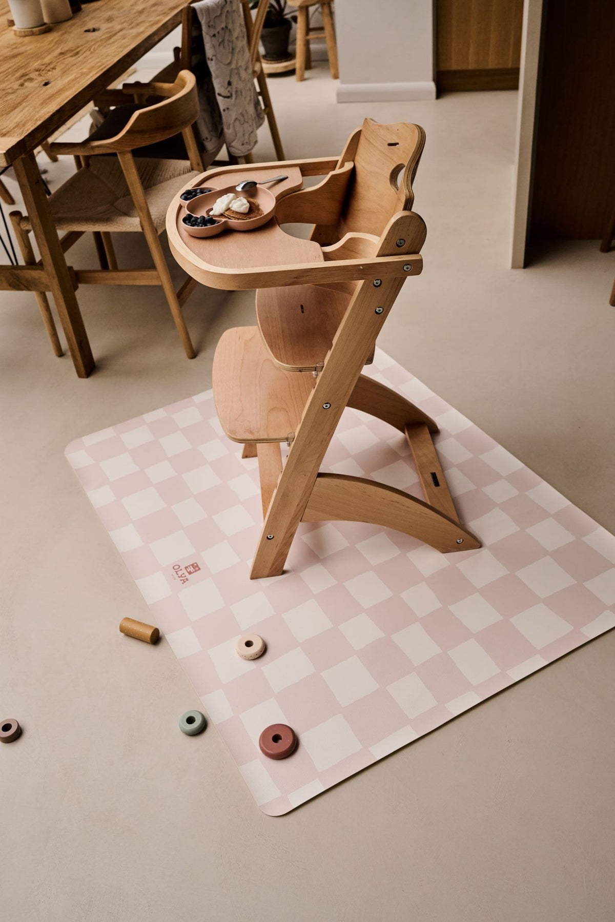 1. Wooden high chair on pink and beige checkered OLYA KIDS floor mat in dining room setting