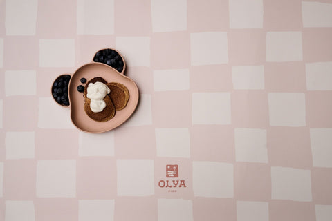 2. Close-up of pink and beige checkered OLYA KIDS floor mat with bear-shaped plate and food