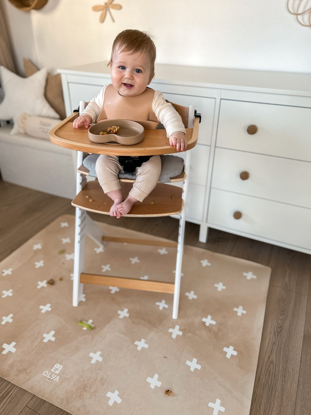 3. Smiling baby in high chair on beige OLYA KIDS floor mat with cross pattern, in bright room