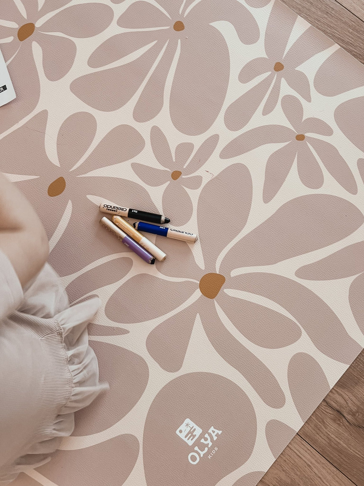 3. Close-up of pink daisy-patterned OLYA KIDS floor mat with markers