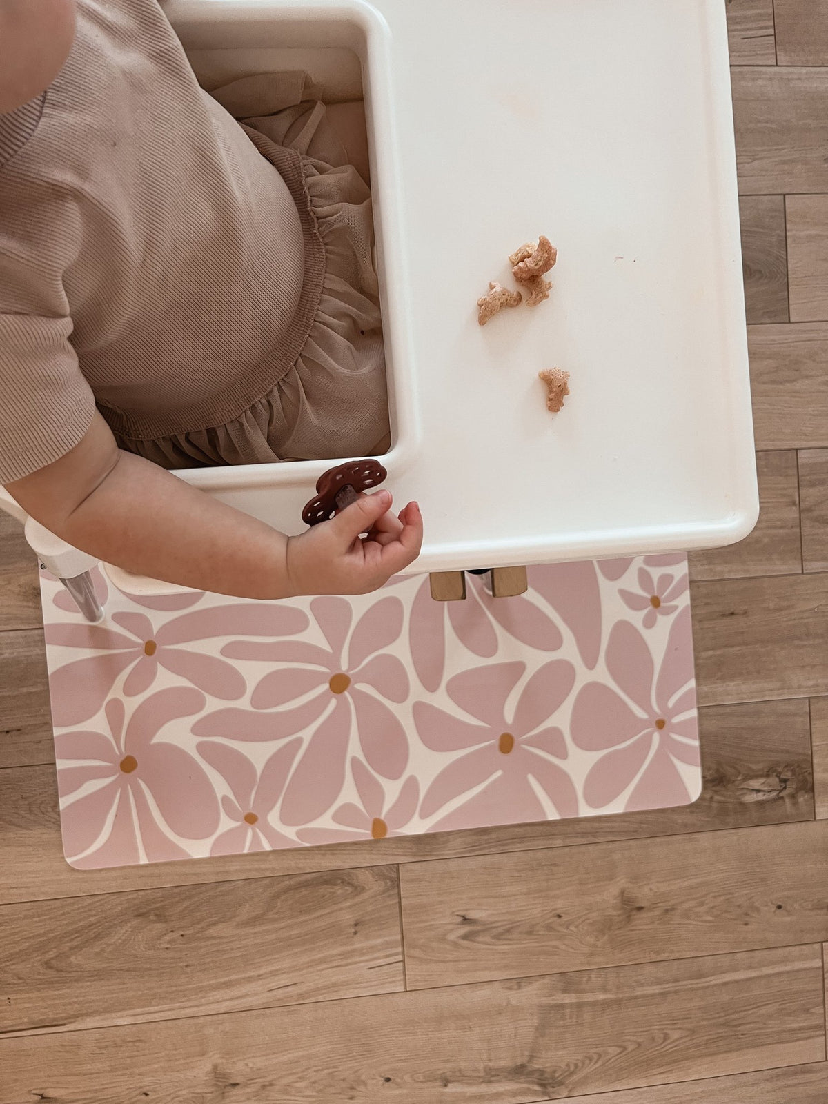 3. Close-up of toddler's hand on pink daisy-patterned OLYA KIDS floor mat