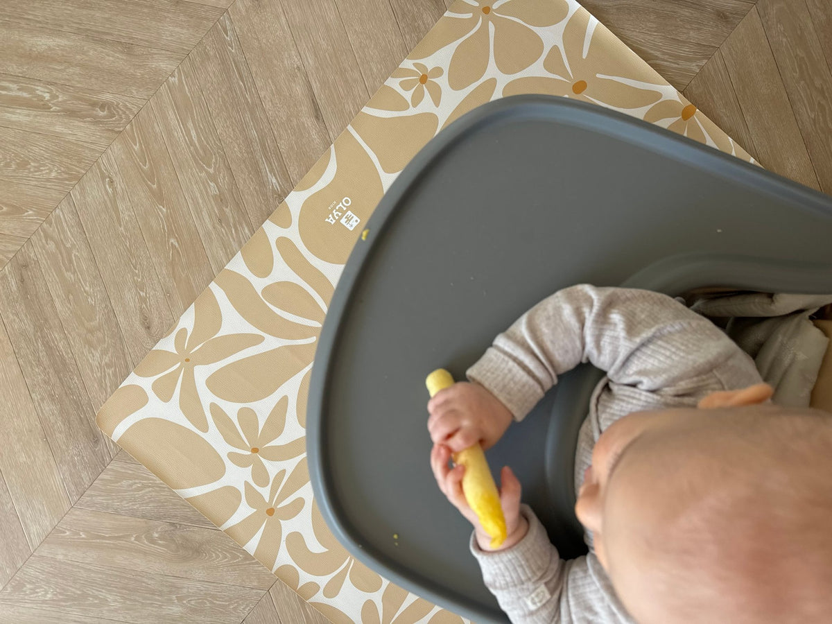 3. Close-up of baby in high chair on beige daisy-patterned OLYA KIDS floor mat