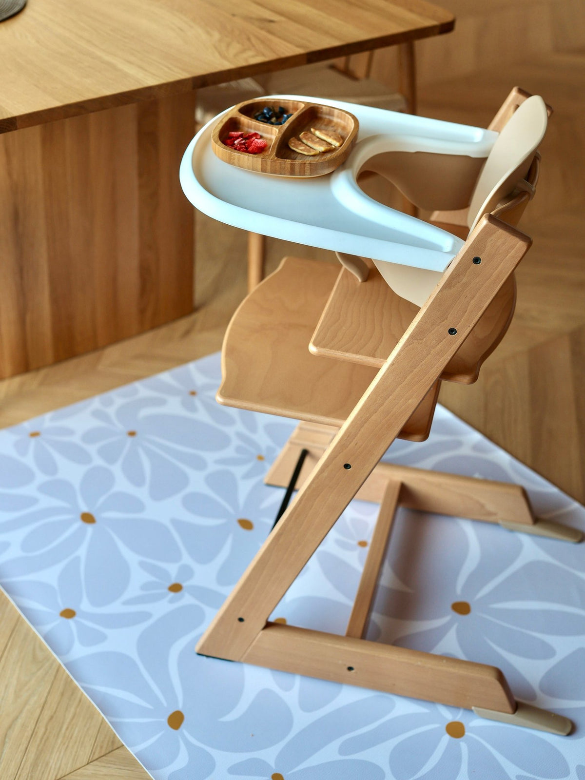 7. Top view of high chair on lavender daisy-patterned floor mat in dining room