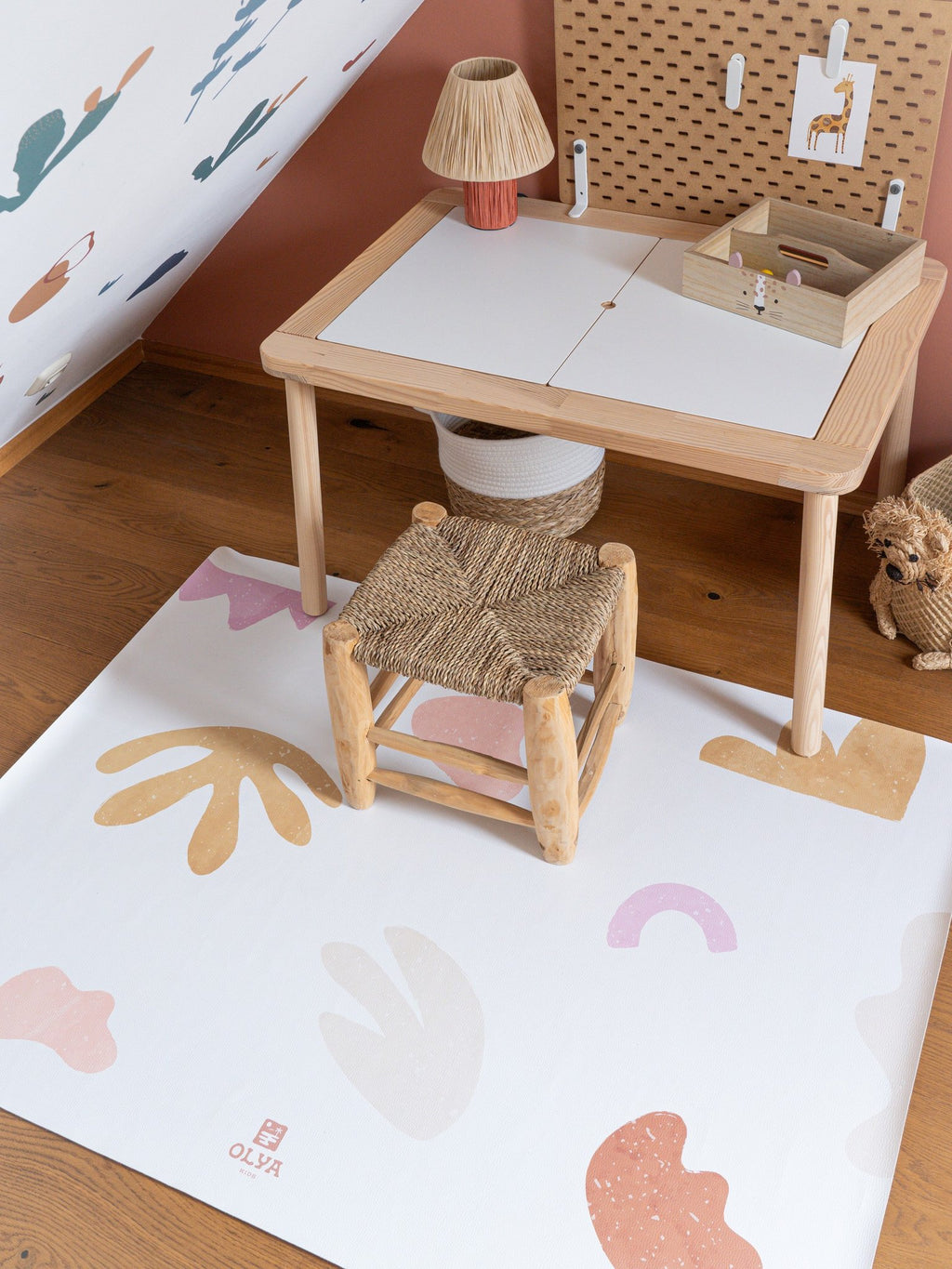 1. Kids' playroom with OLYA KIDS non-slip waterproof floor mat under wooden table and chair, featuring abstract patterns in pastel colors on wooden floor