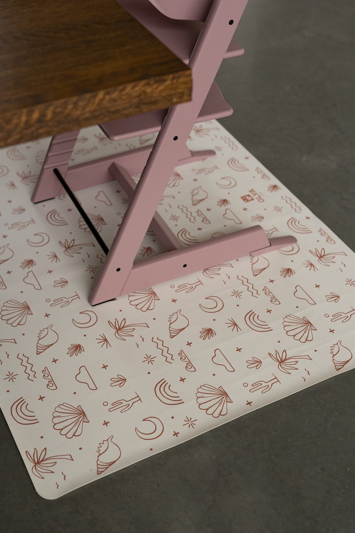 3. Close-up of pink high chair on OLYA KIDS palm beach terra floor mat with beach-themed print