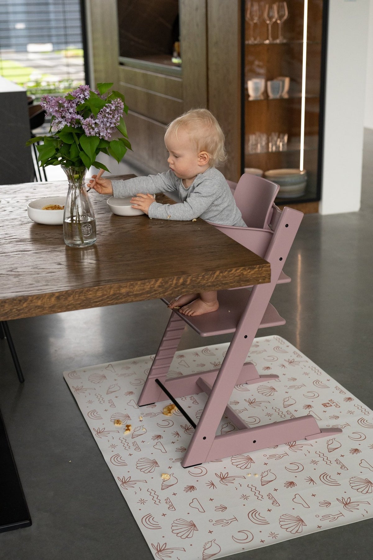 6. Child sitting in pink high chair on OLYA KIDS palm beach terra floor mat at dining table